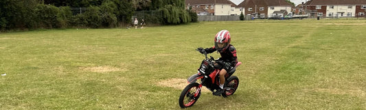 Child riding a Kubbi electric scrambler across grass