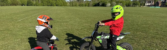 Two young children in full-face helmets on small Kubbi electric bikes