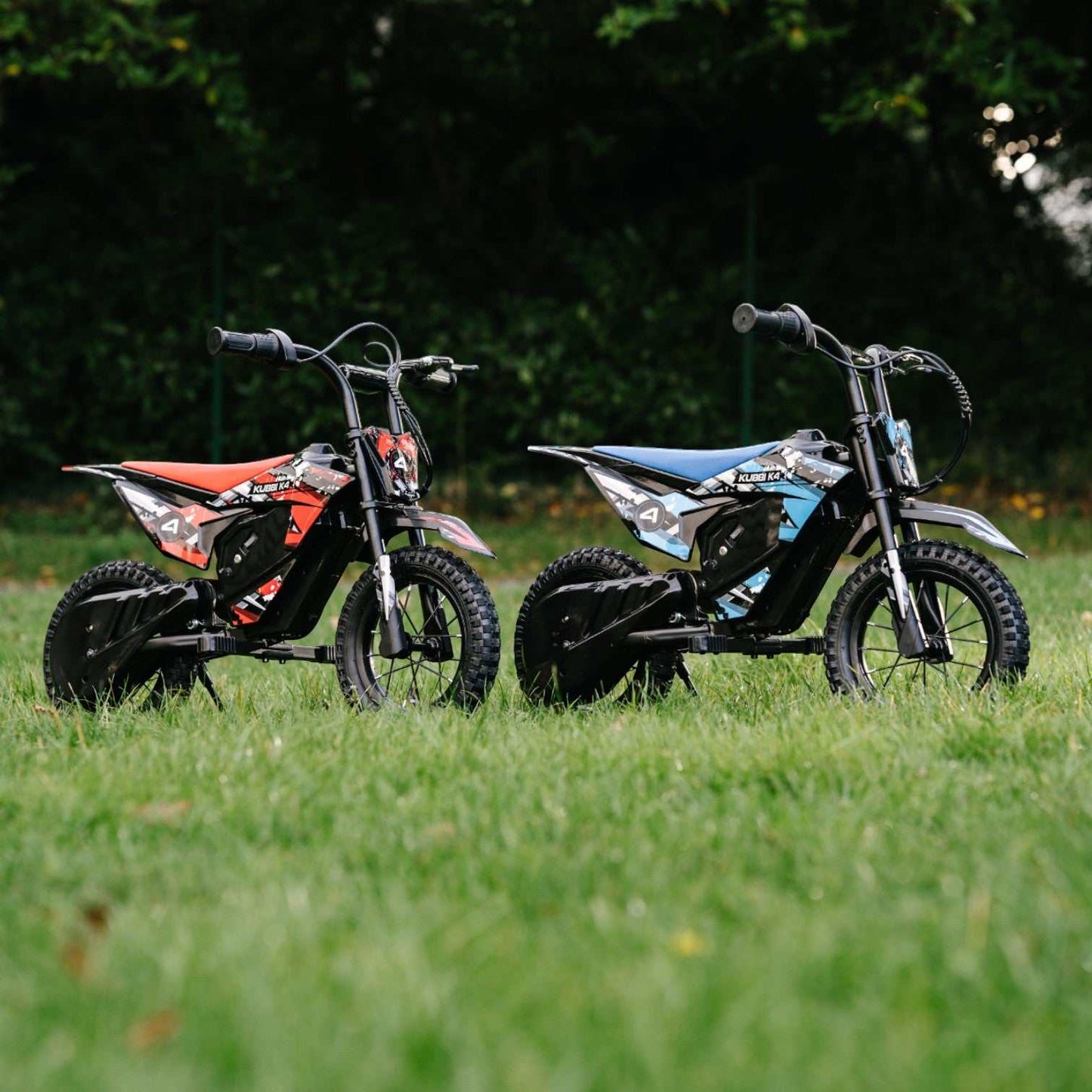 Two Kubbi K4 Dirt Bikes for kids with off-road tires on grass