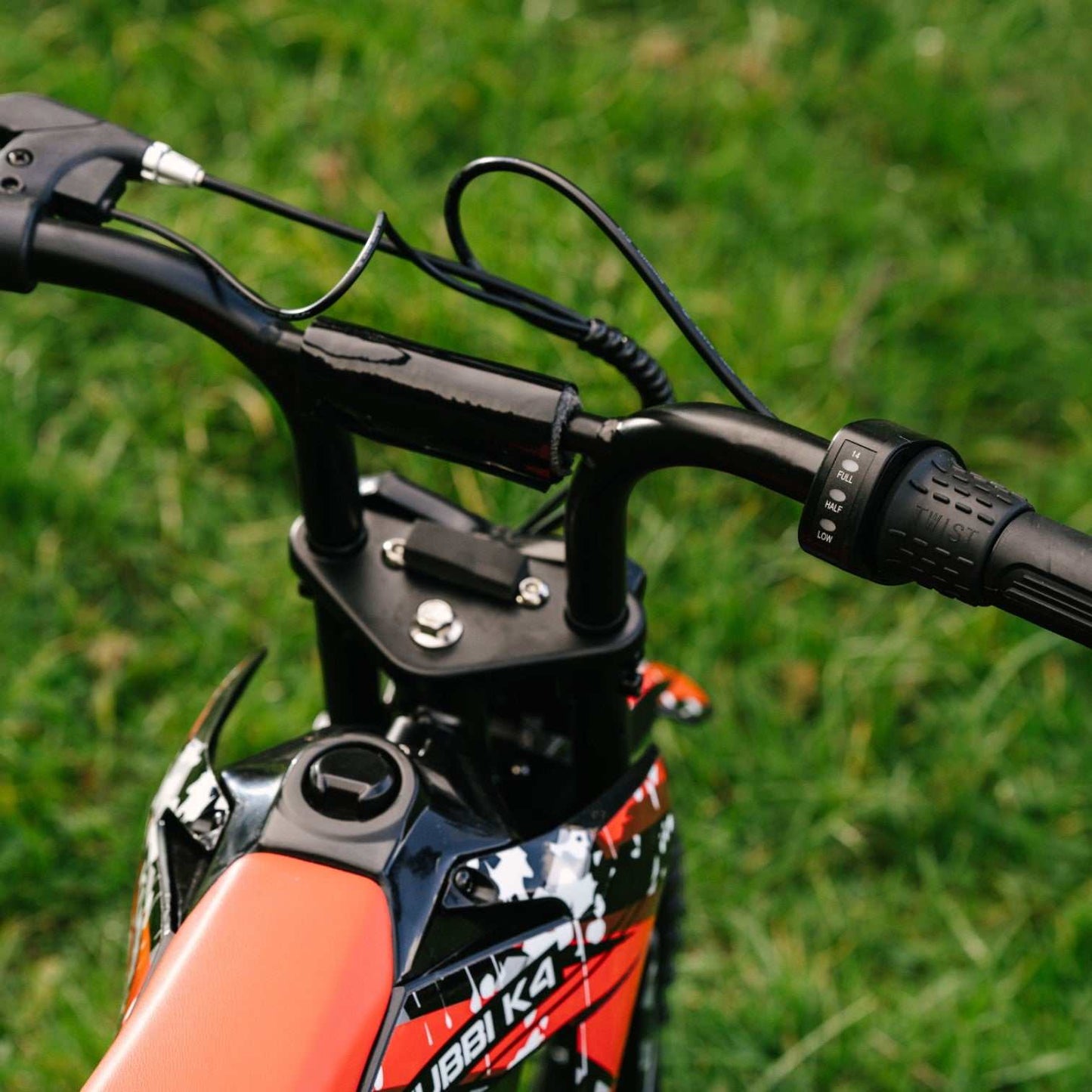 Kubbi K4 Dirt Bike kids electric bike with 12-inch off-road tires and 150W motor on grass background