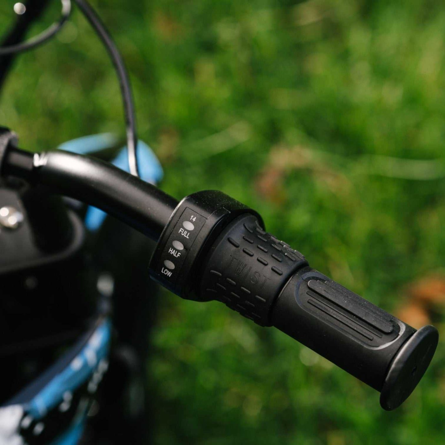 Kubbi K4 Dirt Bike kids electric dirt bike handlebar with speed control settings in outdoor grassy area