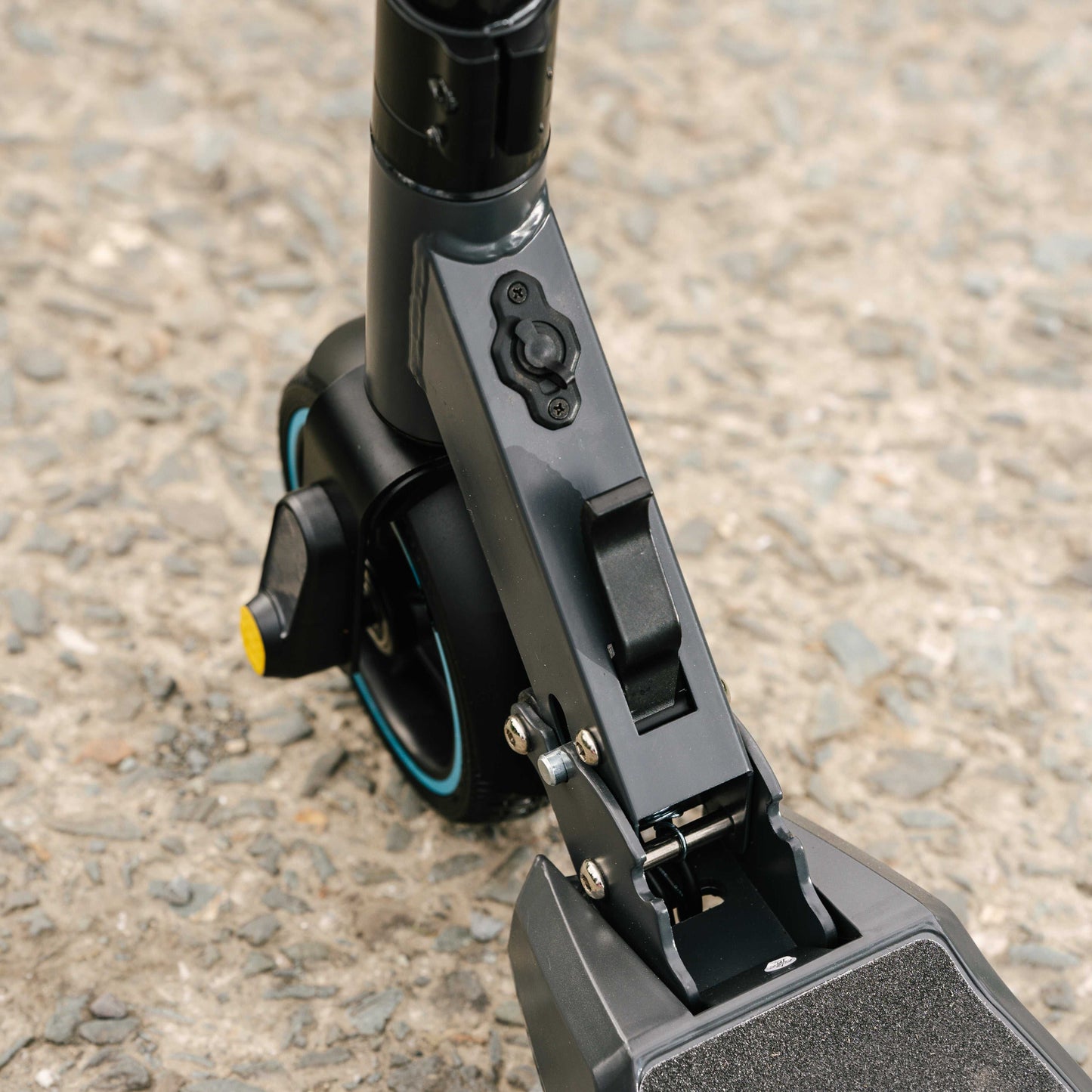 Close-up of Kubbi S9 Pro electric scooter folding mechanism and front wheel on pavement