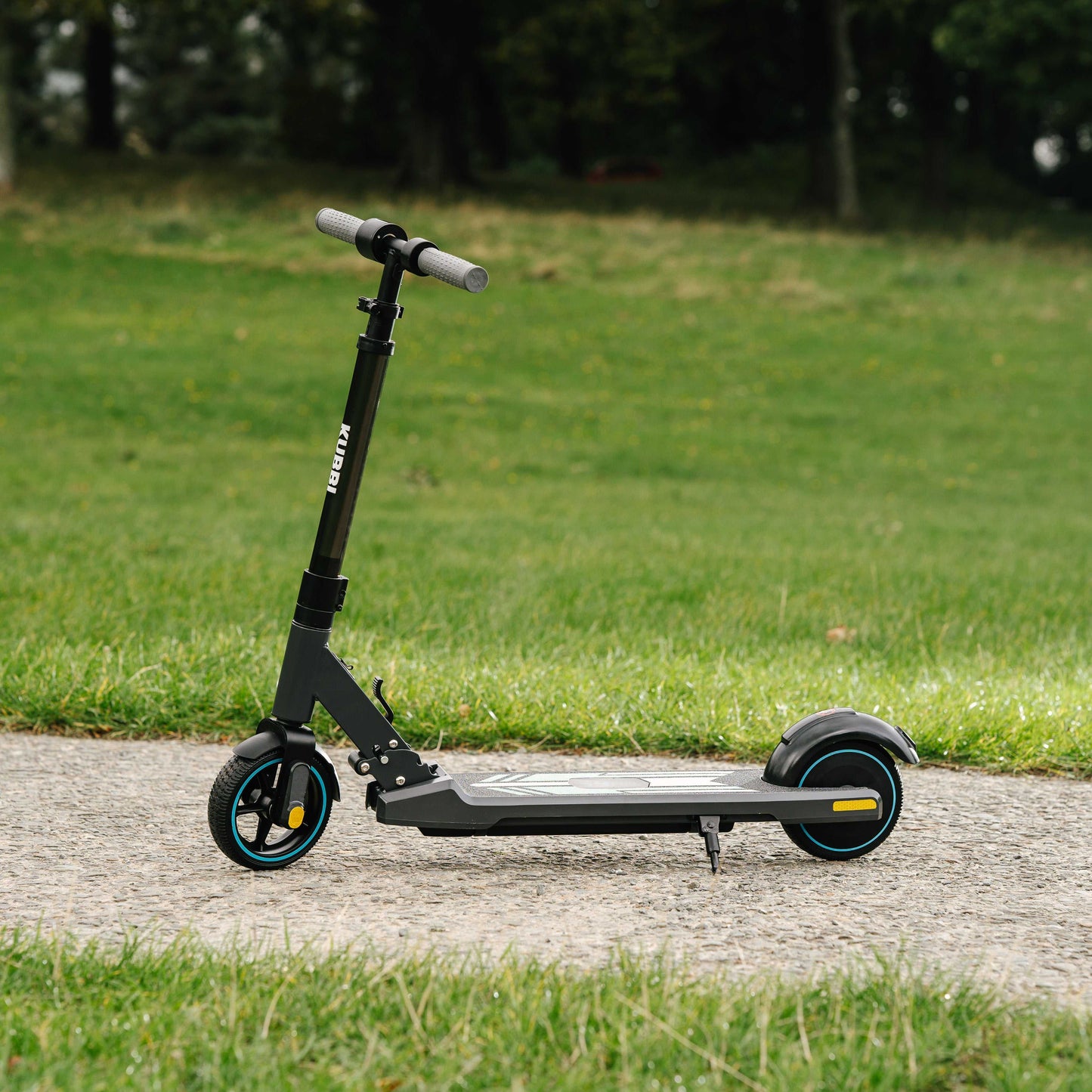 Kubbi S9 Pro electric scooter on pavement with green grass background