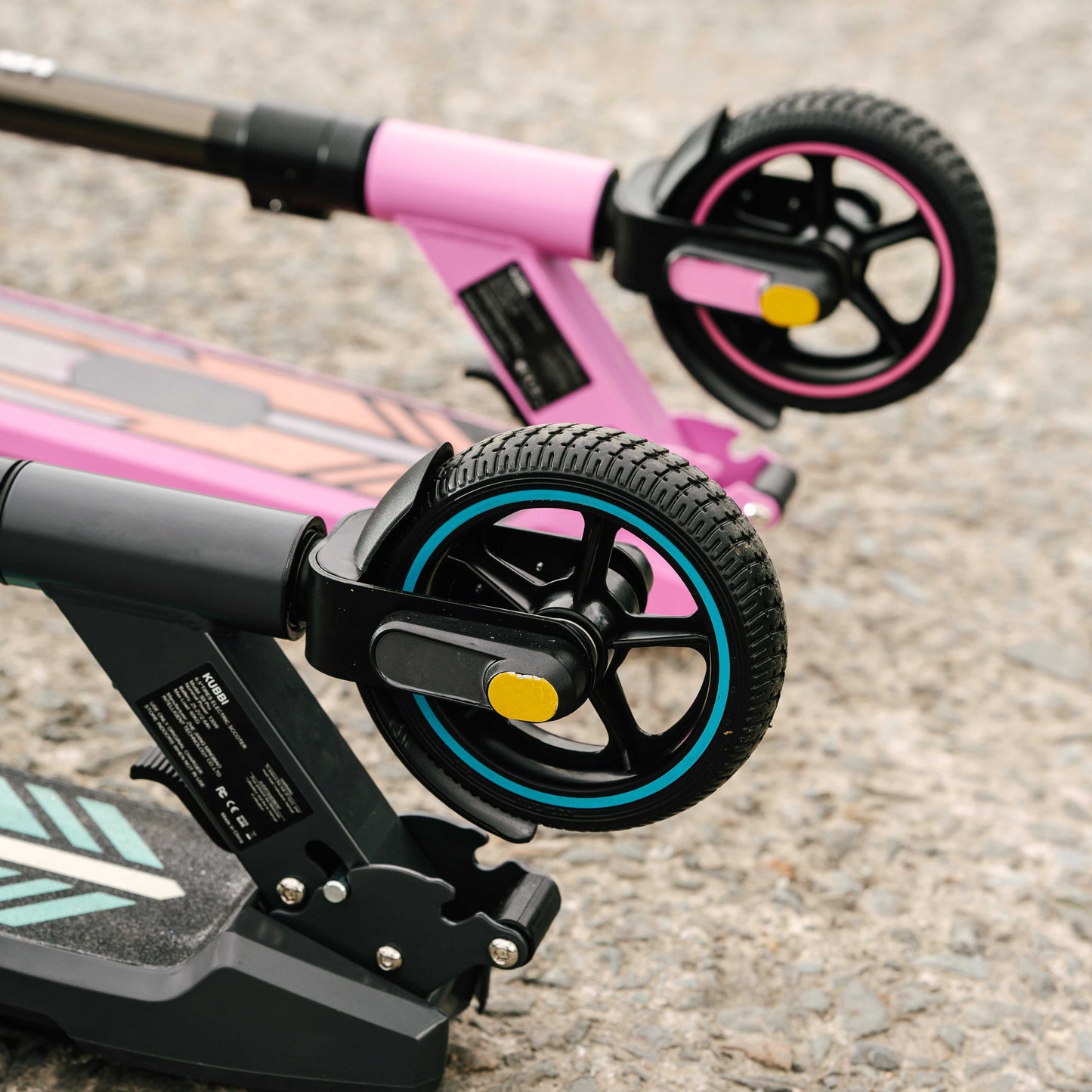 Folded Kubbi S9 Pro electric scooters with close-up of front wheels on pavement