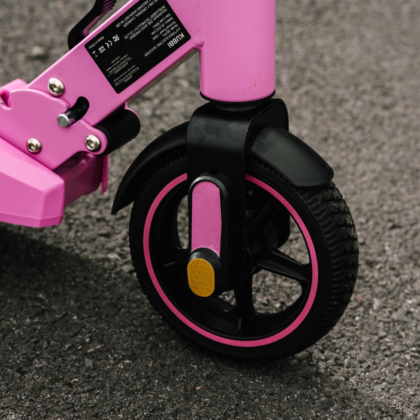 Close-up of pink Kubbi S9 Pro electric scooter front wheel and frame on pavement